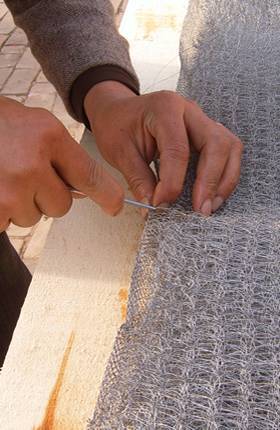A worker is stitching the boarder.