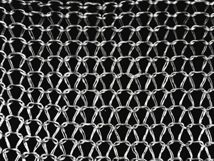 A piece of multi-filament knitted wire mesh on the black background.