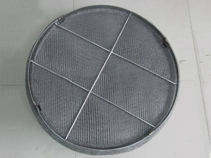 A standard knitted wire mesh demister pad on the ground.